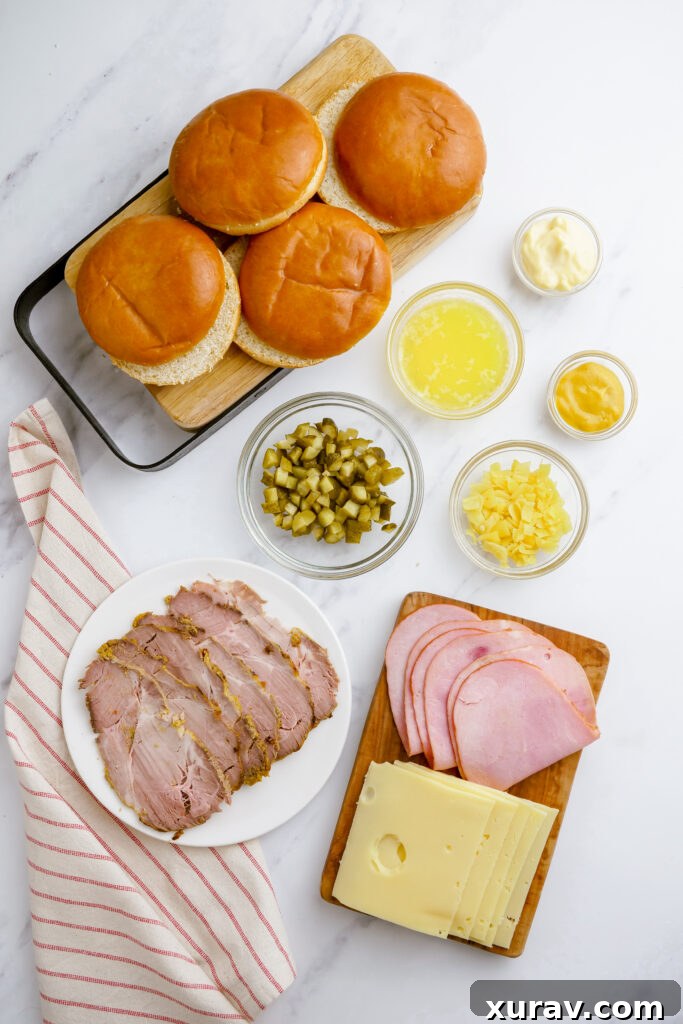 Close-up of a Cuban sandwich showing the layers of ham, roast pork, Swiss cheese, and pickles before being pressed.