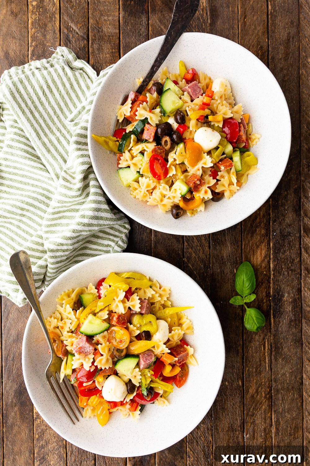 A large serving bowl filled with easy Italian pasta salad, featuring all its colorful and fresh ingredients, ready for a summer potluck or gathering.