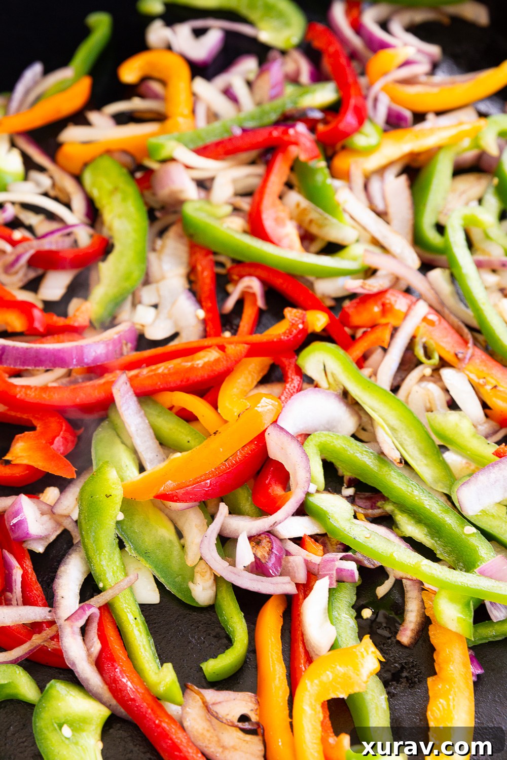 Chicken fajitas vegetables, a colorful medley of onions and bell peppers sizzling in the pan.
