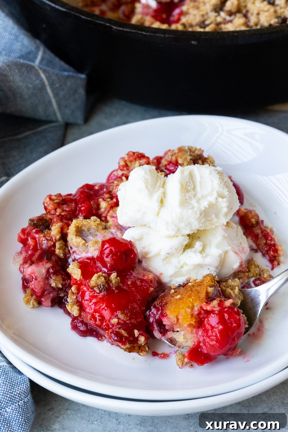 Cherry Cobbler, a tart cherry cobbler made in a dutch oven or cast iron skillet, brimming with ruby-red Montmorency tart cherries.