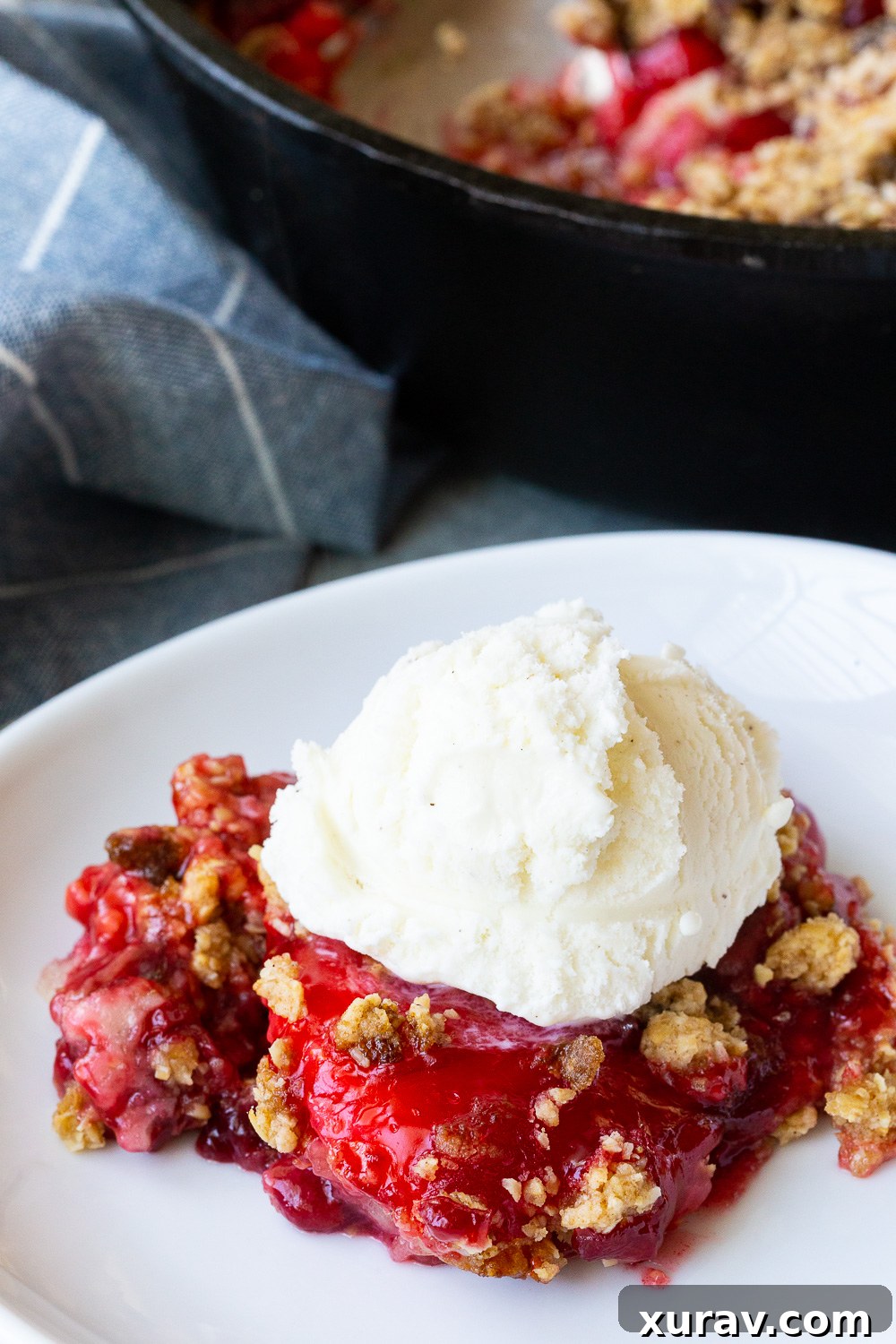 Easy cherry cobbler with an oatmeal crumble, and topped with ice cream, ready to be enjoyed as a perfect summer dessert.