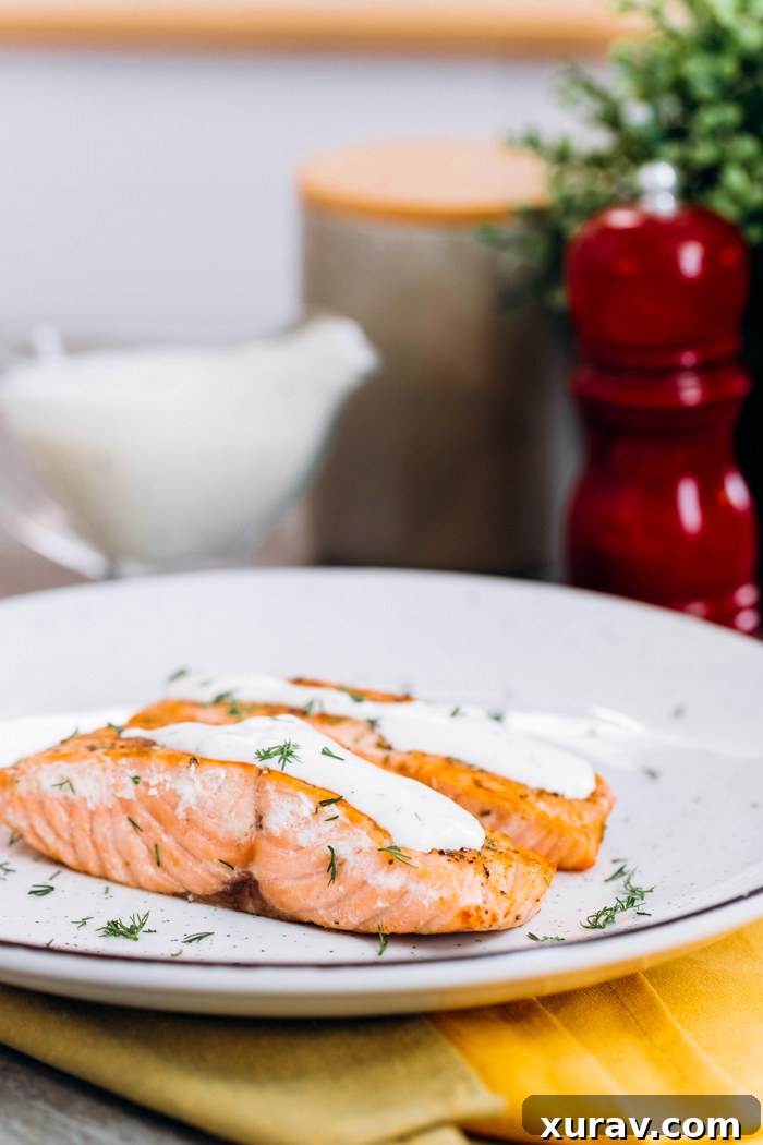 Creamy dill sauce generously poured over perfectly cooked salmon fillets.