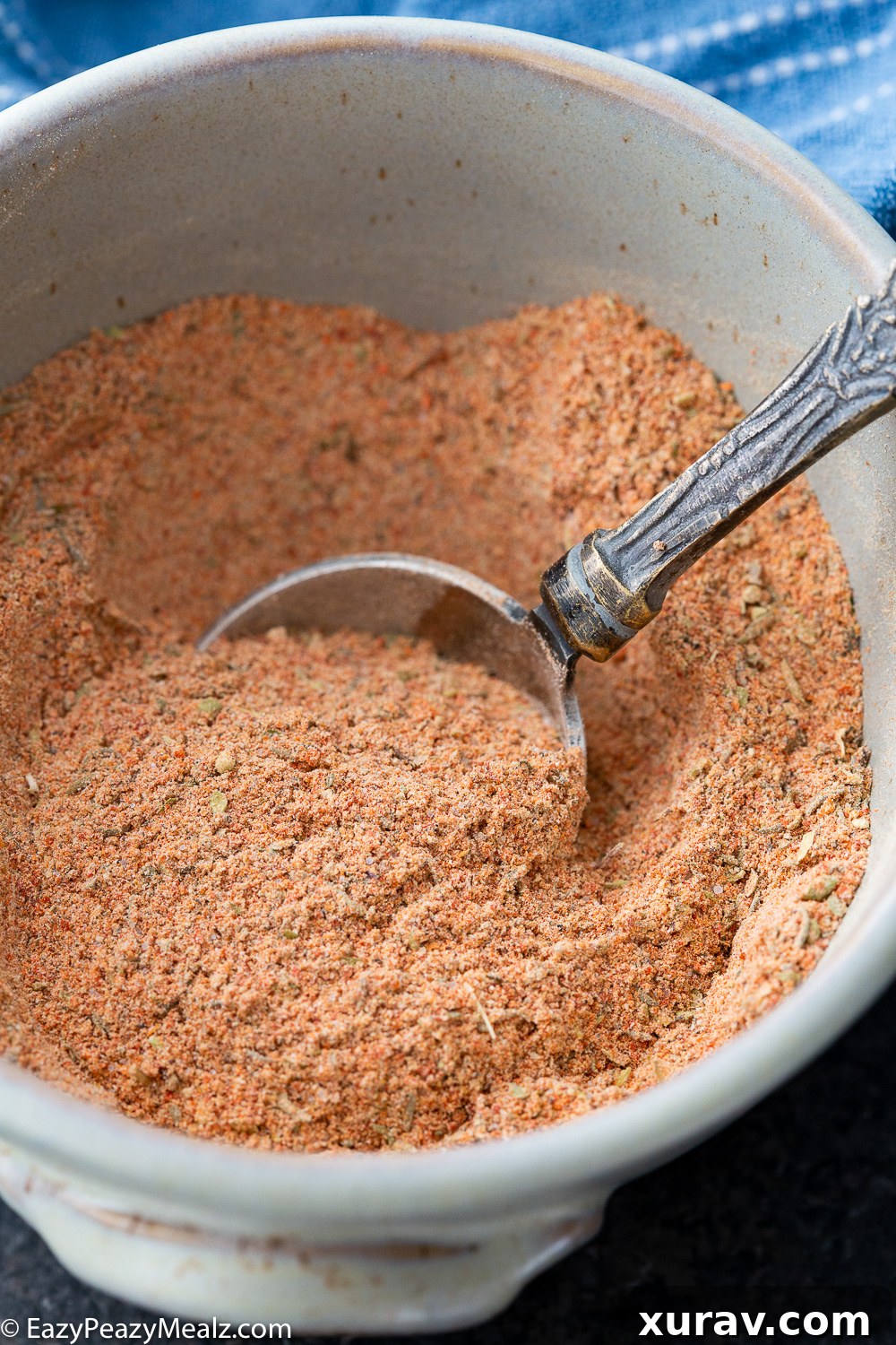 A mixture of homemade spices, specifically a cajun seasoning blend, captured from above in a container.