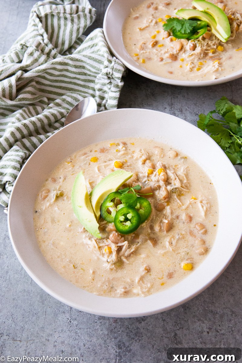 A delicious bowl of creamy slow cooker white chicken chili, garnished with cilantro and sour cream, ready to be enjoyed.