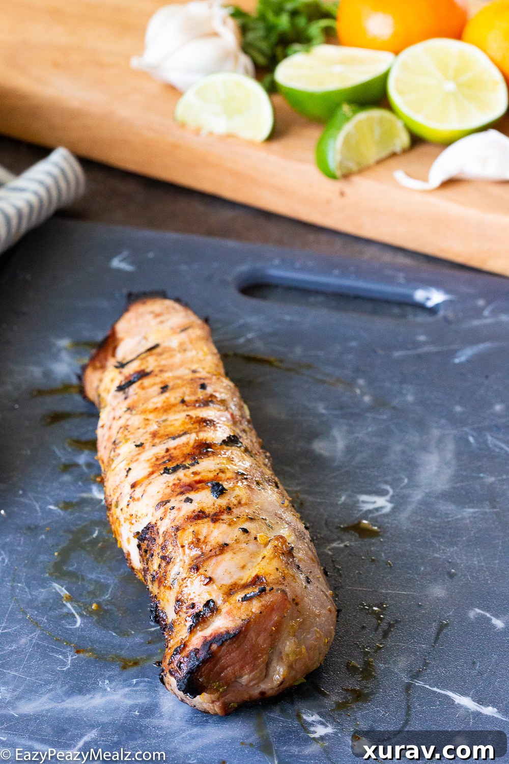 Grilled citrus mojo pork tenderloin resting on a cutting board, ready to be sliced