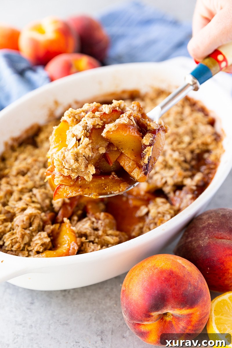 Golden, buttery peach crisp topped with a crisp oat crumble and served warm with a scoop of melting vanilla ice cream.