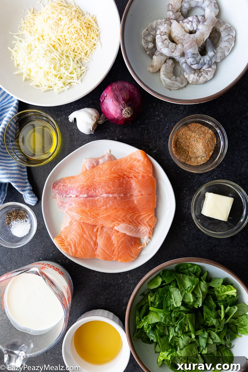 Ingredients for Cajun salmon and shrimp recipe: fresh salmon fillets, raw shrimp, Cajun seasoning, garlic, spinach, shredded cheese, cream