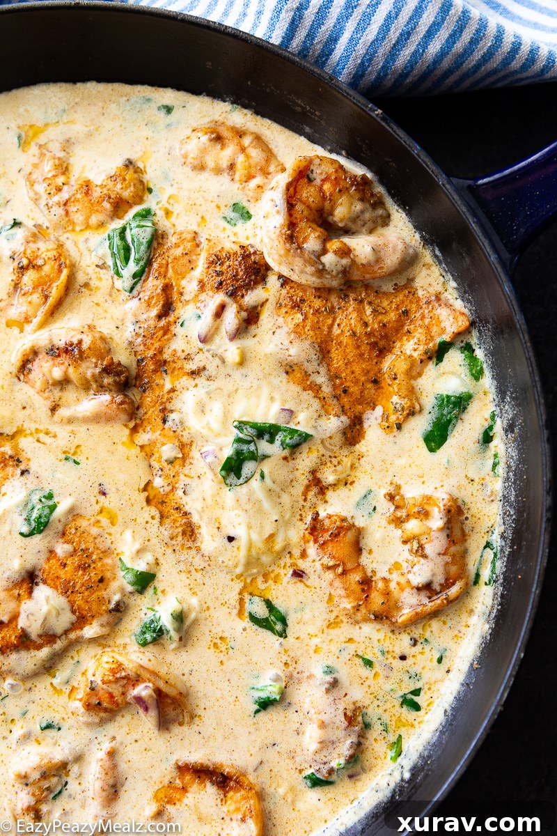 A skillet of cajun salmon and shrimp in a cheesy cream and spinach sauce. 