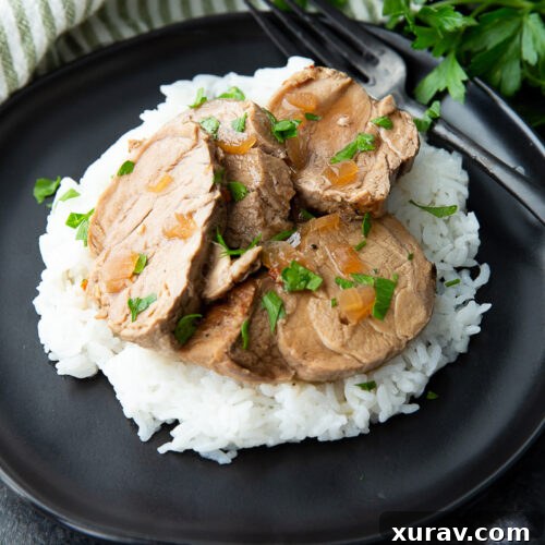 Slow cooker pork tenderloin with teriyaki sauce, garnished with sesame seeds and green onions.