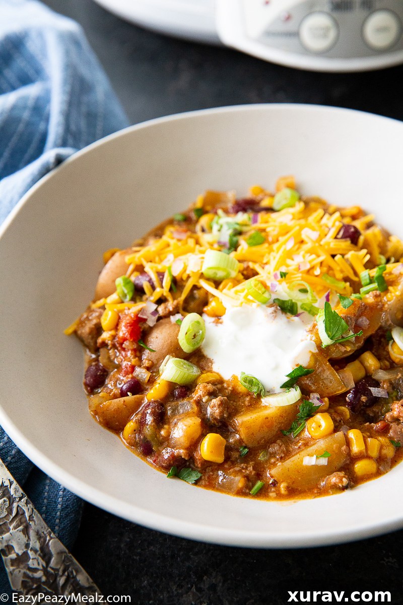 Hearty Slow Cooker Cowboy Casserole topped with melted cheese and a dollop of sour cream, ready to serve.