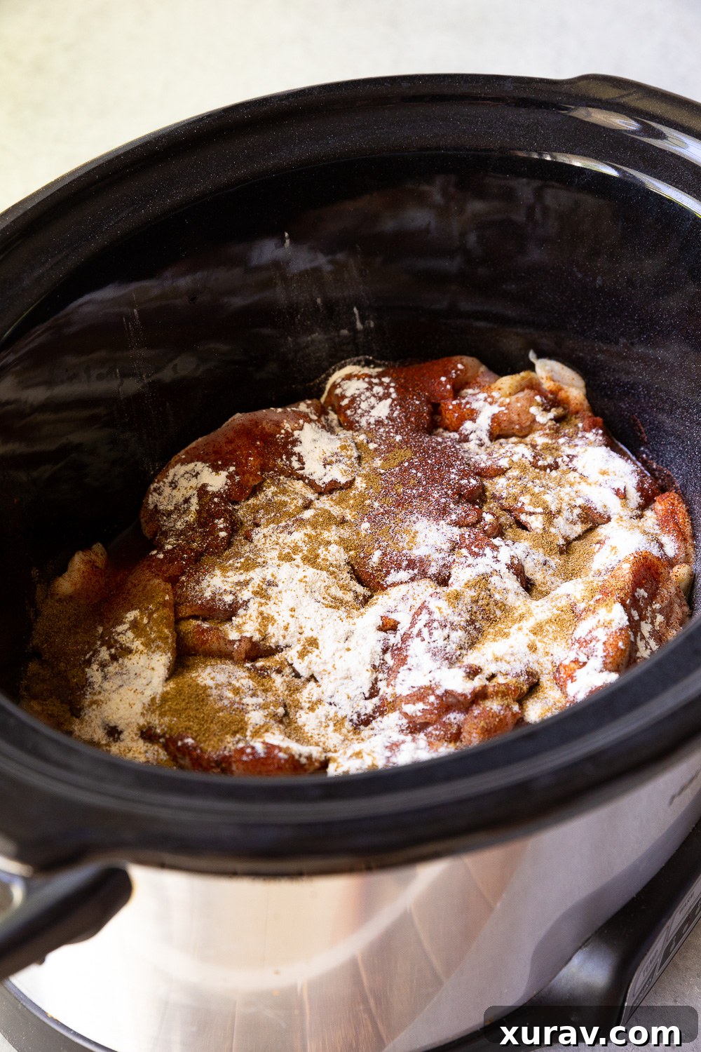 Slow cooker filled with salsa verde chicken before cooking