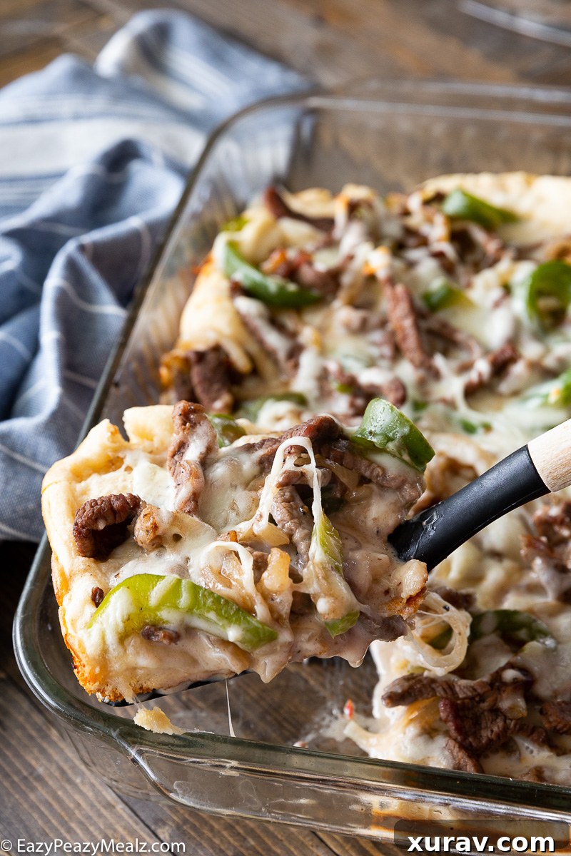 A golden, bubbly Philly Cheesesteak Bake with a flaky crust, filled with steak, peppers, onions, and melted cheese.
