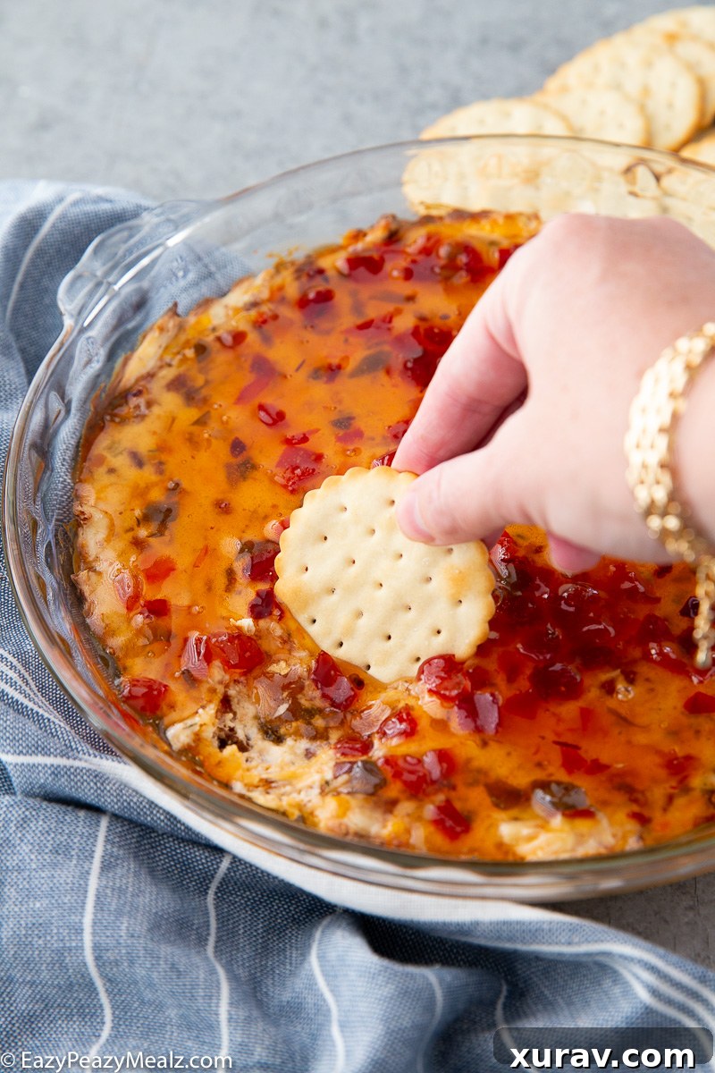Warm Bacon Pepper Jelly Dip served with crackers on a white platter.