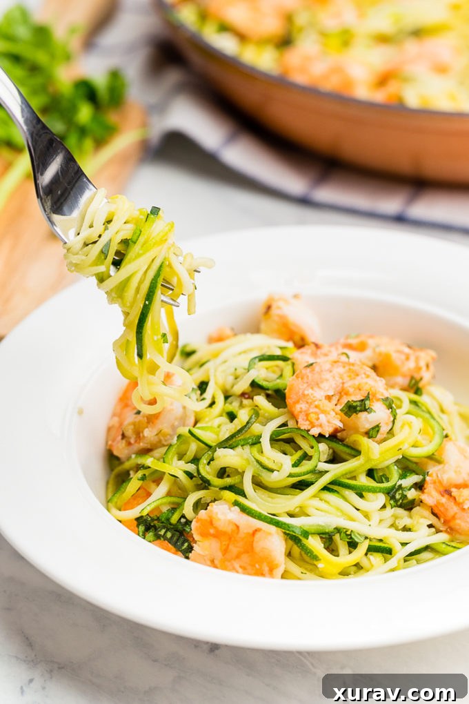 Close-up of a fork lifting a perfect bite of Zucchini Noodle Shrimp Scampi