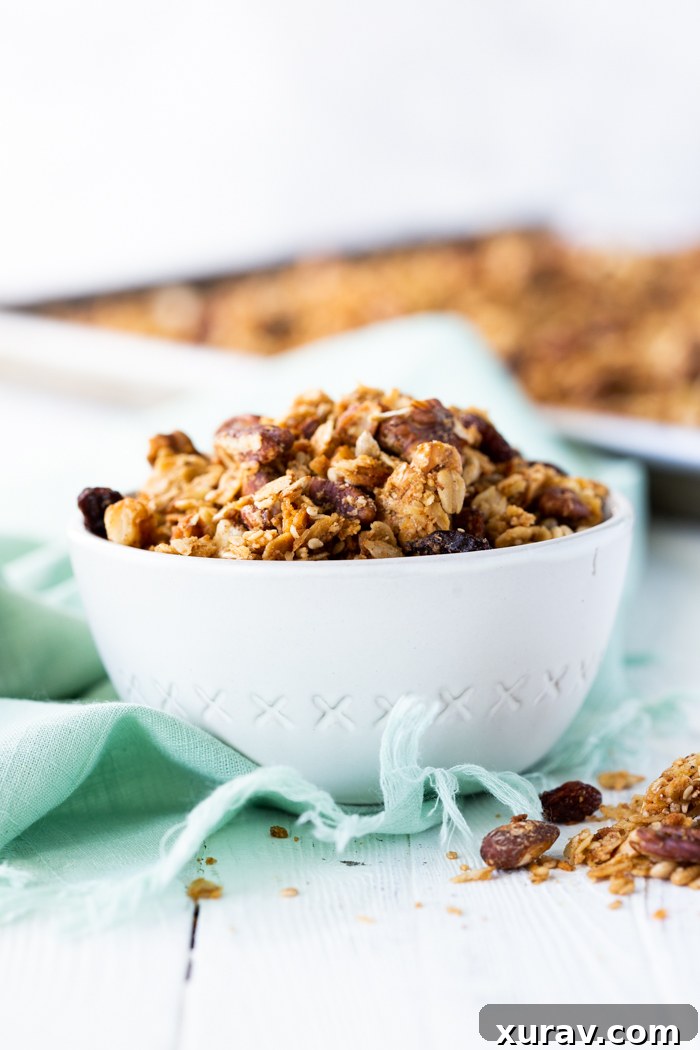 A beautiful bowl of freshly made homemade granola, adorned with fresh berries, ready to be enjoyed as a healthy breakfast or snack.